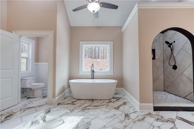 bathroom featuring marble finish floor, a wealth of natural light, a soaking tub, and toilet