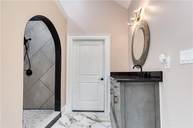 full bathroom with marble finish floor, tiled shower, and vanity