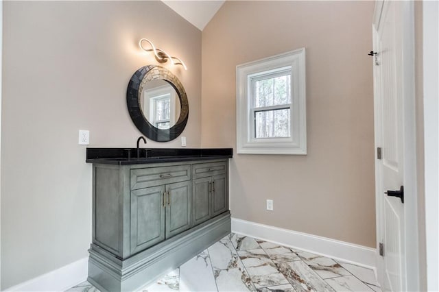 bathroom featuring marble finish floor, vaulted ceiling, vanity, and baseboards