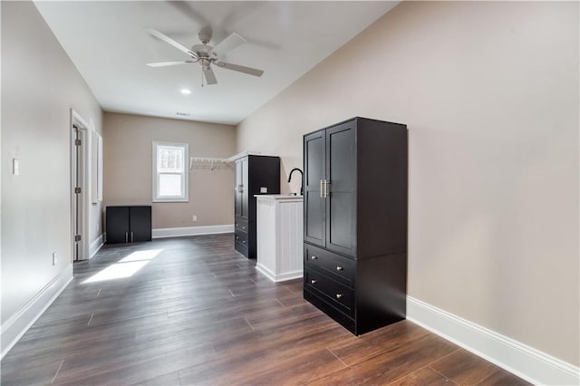 interior space featuring dark wood finished floors, a ceiling fan, and baseboards