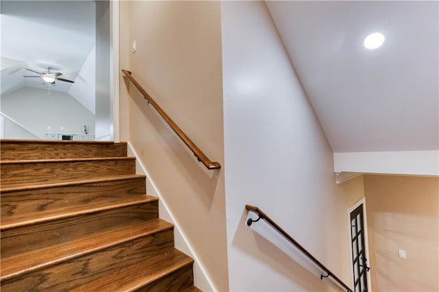 staircase featuring lofted ceiling and a ceiling fan