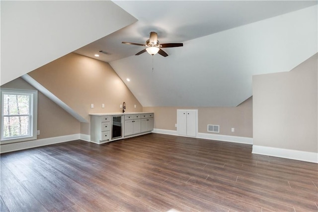 bonus room with lofted ceiling, visible vents, and dark wood finished floors