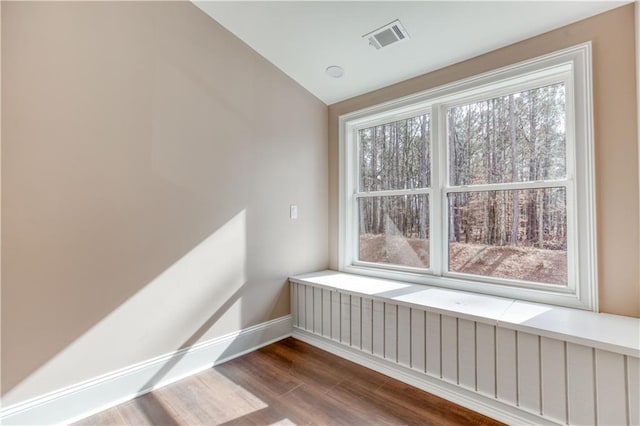 spare room with baseboards, visible vents, a wealth of natural light, and wood finished floors