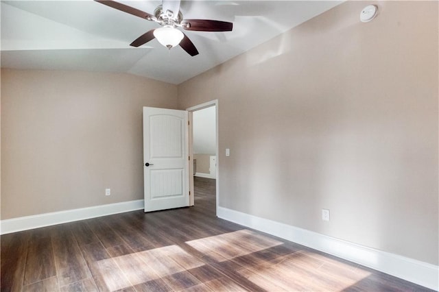 empty room with lofted ceiling, ceiling fan, baseboards, and dark wood finished floors