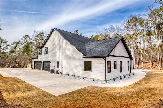 view of property exterior featuring a garage, central AC, a shingled roof, concrete driveway, and a lawn