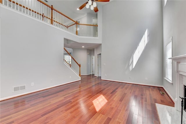 3805 Roxwood Park Dr, Buford, GA 30518 - unfurnished living room featuring a high ceiling, a ceiling fan, a high end fireplace, stairs, and baseboards