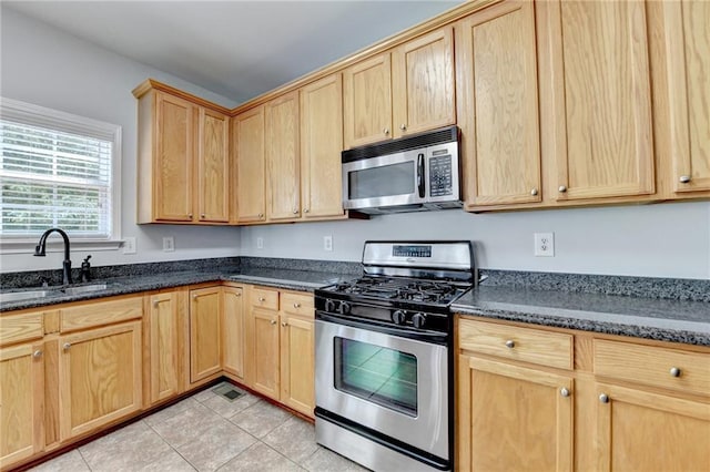 3805 Roxwood Park Dr, Buford, GA 30518 - kitchen with stainless steel appliances, a sink, light brown cabinetry, light tile patterned floors, and dark stone countertops