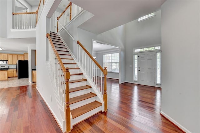 3805 Roxwood Park Dr, Buford, GA 30518 - foyer entrance featuring a high ceiling, stairs, baseboards, and light wood-style flooring