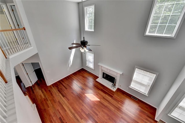 3805 Roxwood Park Dr, Buford, GA 30518 - unfurnished living room with a high end fireplace, a towering ceiling, plenty of natural light, and wood finished floors
