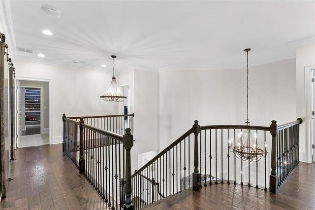 corridor featuring ornamental molding, dark hardwood / wood-style floors, and a chandelier