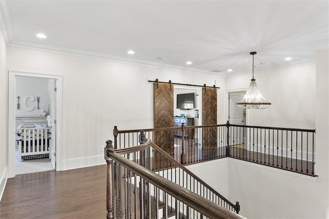 hallway featuring ornamental molding, hardwood / wood-style floors, and a barn door