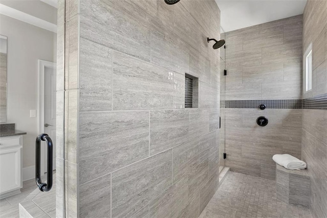 bathroom featuring a shower with door and vanity