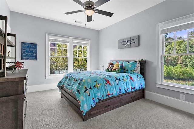 carpeted bedroom featuring ceiling fan and multiple windows