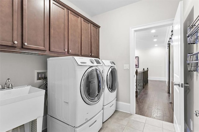 washroom with sink, washer and clothes dryer, light tile patterned flooring, and cabinets