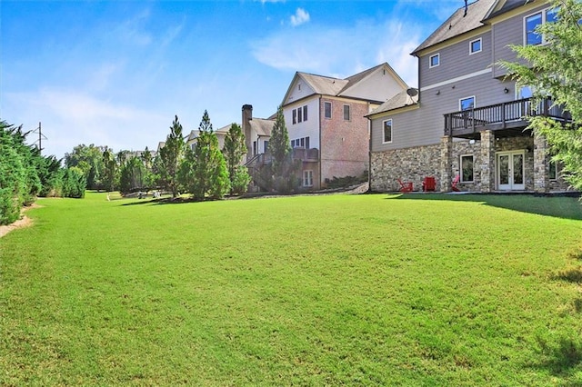 view of yard with french doors and a wooden deck