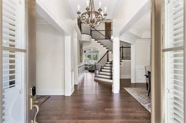 foyer featuring ornamental molding, a notable chandelier, dark hardwood / wood-style flooring, and radiator heating unit