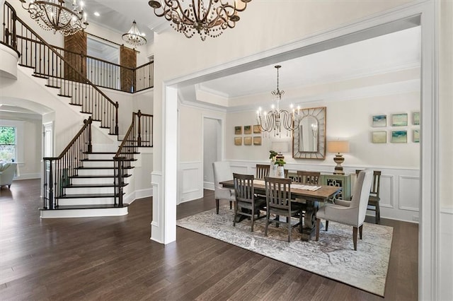 dining space with dark wood-type flooring, a notable chandelier, and crown molding