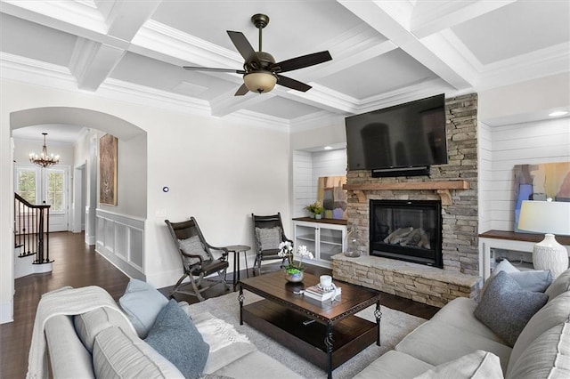 living room featuring coffered ceiling, a stone fireplace, and beam ceiling