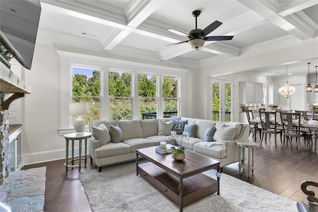 living room with beamed ceiling, ceiling fan with notable chandelier, coffered ceiling, crown molding, and dark wood-type flooring