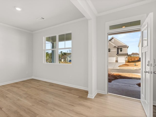 empty room with ornamental molding, baseboards, and wood finished floors