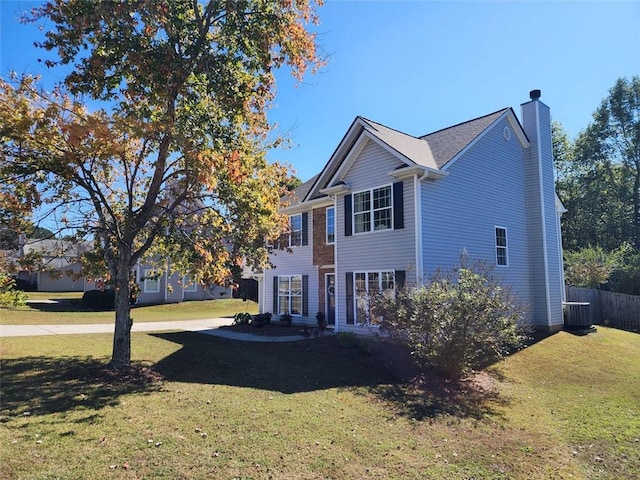 view of front of property featuring a front yard and central AC