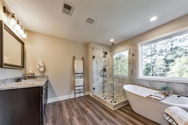 bathroom featuring hardwood / wood-style floors, shower with separate bathtub, and vanity