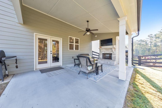 view of patio with ceiling fan, an outdoor stone fireplace, and grilling area