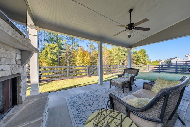 view of patio with an outdoor living space with a fireplace and ceiling fan