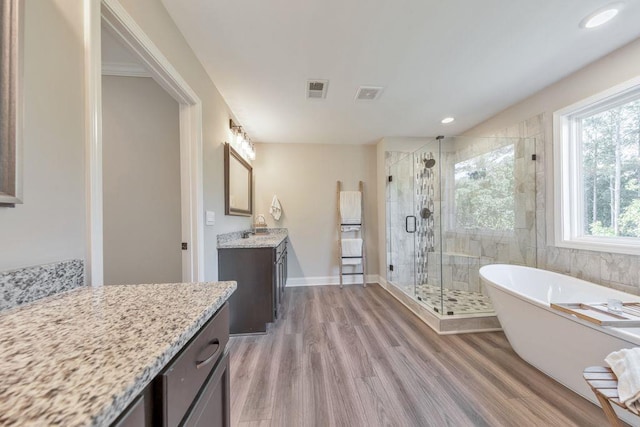 bathroom with independent shower and bath, vanity, and wood-type flooring