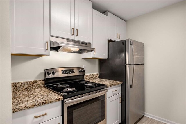3655 Habersham Rd NE Unit 203, Atlanta, GA 30305 - kitchen with appliances with stainless steel finishes, under cabinet range hood, light stone countertops, white cabinets, and light wood-type flooring