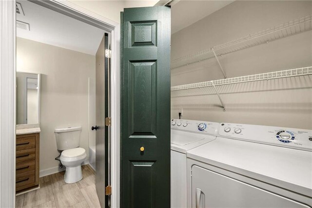 3655 Habersham Rd NE Unit 203, Atlanta, GA 30305 - laundry room with washing machine and clothes dryer, light wood-style flooring, and baseboards