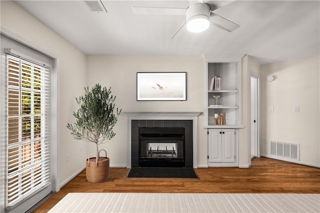 3655 Habersham Rd NE Unit 203, Atlanta, GA 30305 - living room with a tiled fireplace, wood finished floors, a ceiling fan, and baseboards