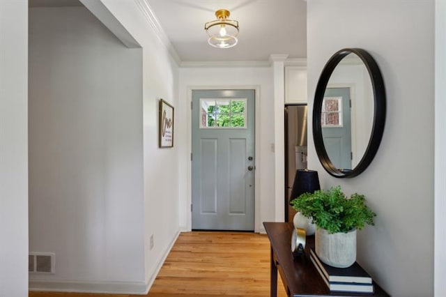 doorway with crown molding and light hardwood / wood-style flooring