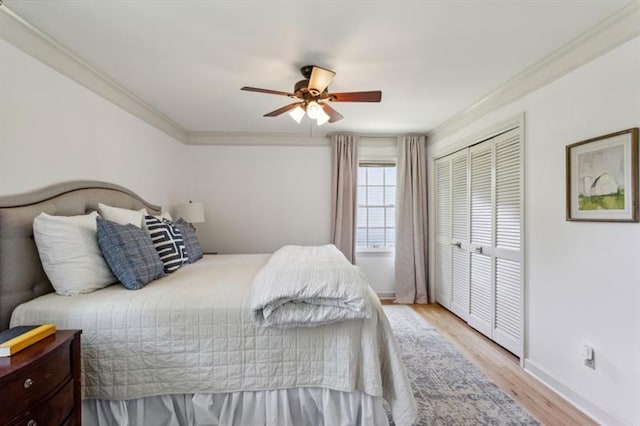 bedroom with crown molding, ceiling fan, light hardwood / wood-style floors, and a closet