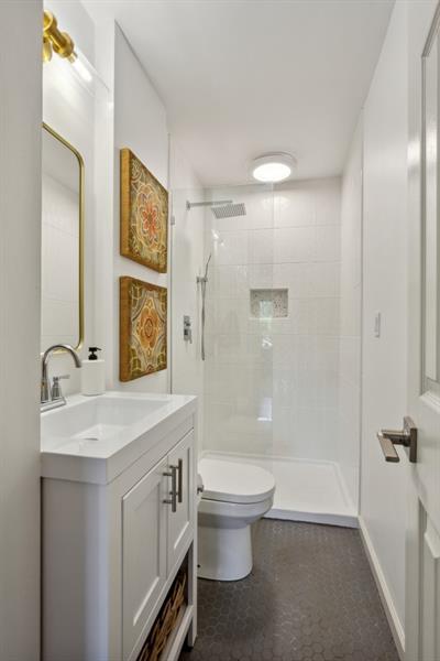 bathroom with vanity, toilet, and a tile shower