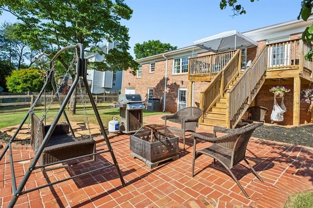 view of patio with area for grilling, a playground, and an outdoor fire pit