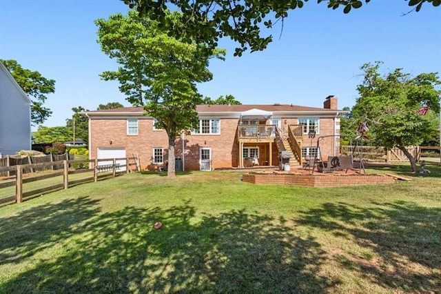 back of property with a wooden deck, a patio, and a lawn