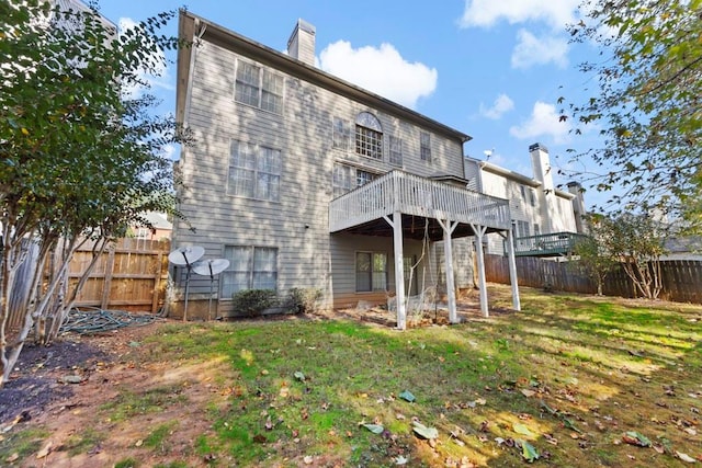 back of house featuring a deck and a yard