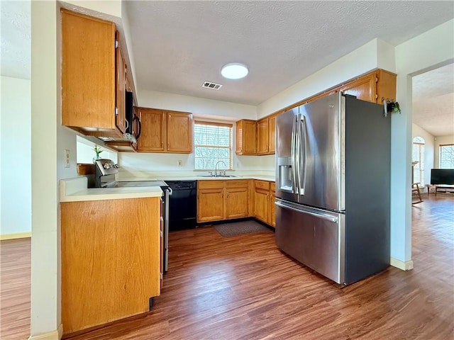 kitchen with dark hardwood / wood-style flooring, sink, a textured ceiling, and black appliances