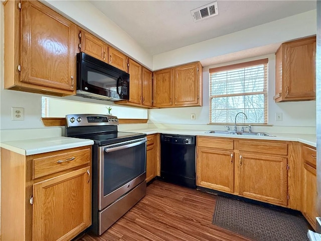 kitchen featuring sink, dark wood-type flooring, and black appliances