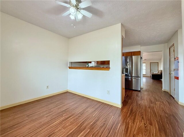 spare room featuring ceiling fan, dark hardwood / wood-style floors, and a textured ceiling