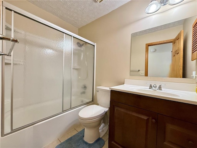 full bathroom featuring combined bath / shower with glass door, vanity, toilet, tile patterned floors, and a textured ceiling