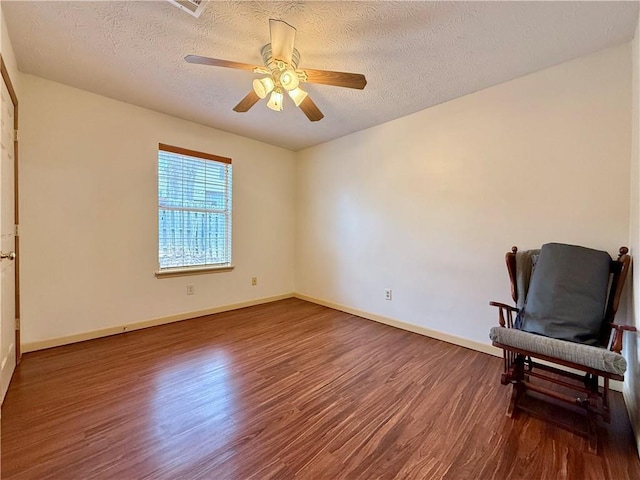 sitting room featuring hardwood / wood-style floors, a textured ceiling, and ceiling fan