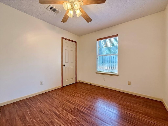 empty room with hardwood / wood-style flooring, ceiling fan, and a textured ceiling