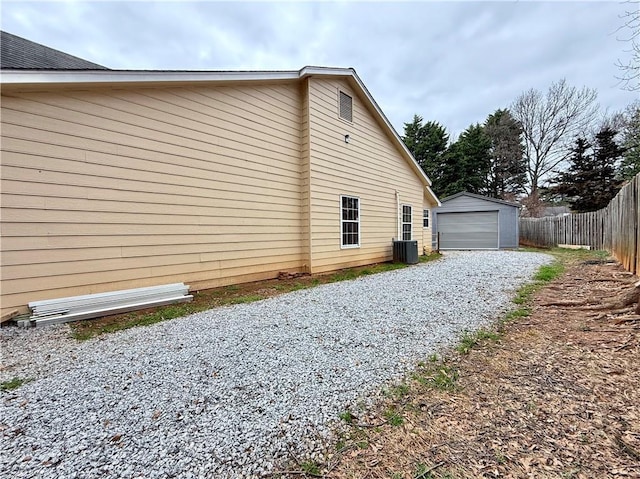 view of side of home featuring an outbuilding, a garage, and central AC