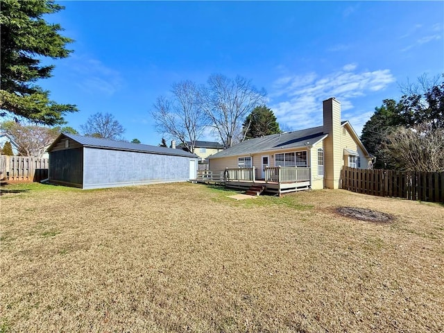 back of property featuring a wooden deck and a lawn