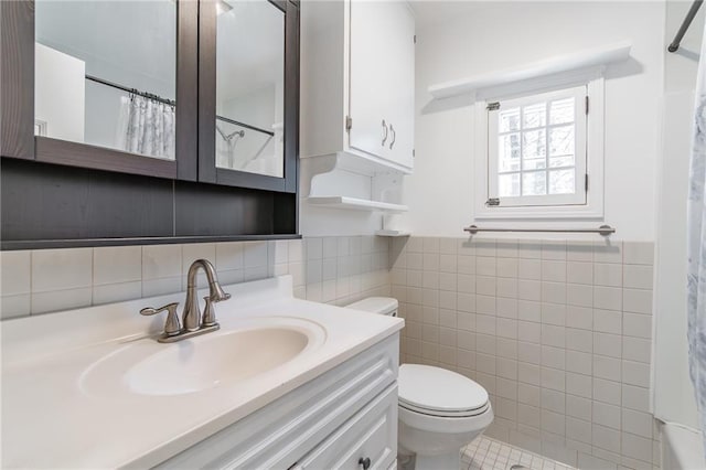 bathroom featuring a shower with curtain, vanity, tile walls, and toilet