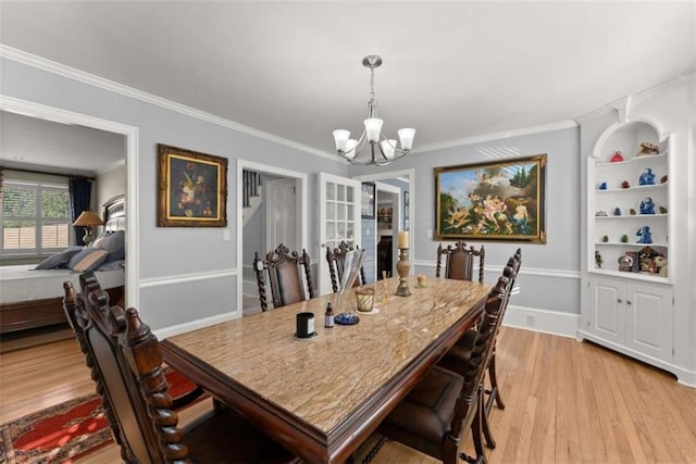 dining room with ornamental molding, light wood finished floors, baseboards, and a notable chandelier