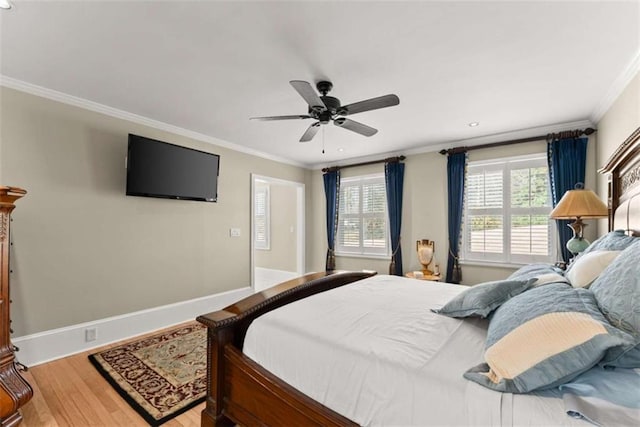 bedroom featuring ornamental molding, multiple windows, wood finished floors, and baseboards