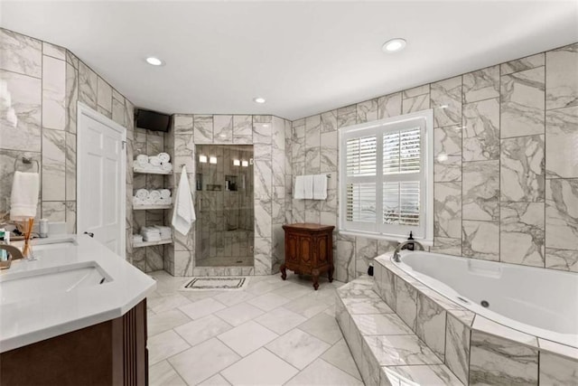 full bathroom featuring double vanity, tile walls, a bath, a shower stall, and a sink